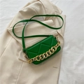 Bright green quilted crossbody bag with gold chain handle on a beige blazer - Green