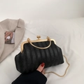 Elegante pochette nera a pieghe con manico in metallo dorato e catena su letto bianco - Nero