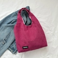Bolso tote de pana rosa con etiqueta Fashion sobre tela blanca y chaqueta vaquera - rosa intenso