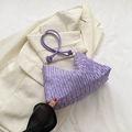 Purple pleated dumpling bag with knotted strap and gold rings on white blazer - Purple