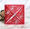 Detailed close-up of red laser-cut wedding invitation with baroque pattern on marble surface - Pearlescent Red
