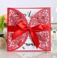 Detailed close-up of laser-cut red rose pattern wedding invitation with a satin bow - Pearlescent Red