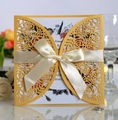 Detail der lasergeschnittenen Hochzeitseinladung mit cremefarbener Seidenschleife - Gold