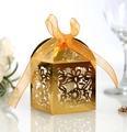 Golden laser-cut wedding candy box with intricate floral hollow design and orange ribbon - Reflective Gold