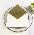Detail of white invitation envelope with elegant gold glitter lining on a luxury plate - Rectangular Gold Glitter Style