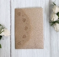Dettaglio dell'invito di nozze glitter oro rosa con intricati motivi floreali tagliati al laser - Oro rosa