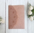Macro detail of laser cut glitter paper rose gold wedding invitation with floral patterns - Apple Gold