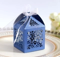 Blue laser-cut candy box with European vine pattern and white ribbon bow on a ceramic plate - Sapphire Blue