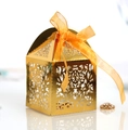 Elegant gold laser-cut candy box with floral patterns and a vibrant orange ribbon - Reflective Gold