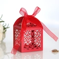 Elegant red laser-cut wedding favor box with intricate hollow patterns and silk ribbon bow - Pearlescent Red