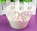 Close-up of white laser-cut cupcake wrapper with elegant rose flower patterns for decoration - Ivory