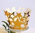 Detalle de moldes dorados para cupcakes con diseño de estrellas cortadas por láser en mesa - Oro Reflectante