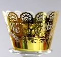 Macro view of gold laser-cut lace cupcake wrappers with elegant floral hollow patterns - Reflective Gold