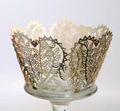 Macro detail of laser-cut cupcake wrapper with champagne gold leaf and floral patterns - Reflective Silver