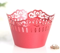 Macro shot of laser-cut red paper cupcake wrapper with elegant lace floral vine patterns - Pearlescent Red