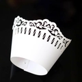 White laser cut lace cupcake wrappers with elegant filigree design on black background - White
