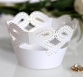 Vista macro di carta decorativa bianca tagliata al laser per cupcake con motivi floreali - Bianco