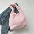 Bolso tote de felpa rosa claro en piel sintética sobre fondo de chaqueta vaquera casual - Sin Adorno / Rosa