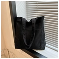 Detalle del bolso tote de pana negra con rayas verticales y un gran bolsillo frontal en ventana - Negro