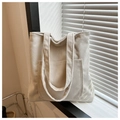 Detalle de un bolso tote de pana blanco crema con textura acanalada y cierre magnético - Blanco