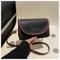 Detailed macro view of black lychee leather bag with brown trim and gold logo - Black