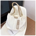 Dettaglio della borsa tote in nylon bianco con manici beige ed etichetta moda su sedia - Bianco