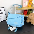 Sky blue canvas messenger bag with fashion label and white drawstring accents - Blue