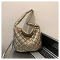 Gesteppte große Tragetasche in Gold-Metallic auf silbernem Stuhl neben einem Laptop - Gold