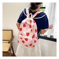 Detail of pink canvas backpack featuring cute strawberry and daisy patterns in soft light - Pink