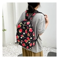 Detailed view of the strawberry and daisy pattern on this black aesthetic school backpack - Black