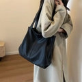 Classic black tote bag with lychee texture leather and spacious interior on a model - Black