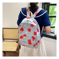 Detail of light blue strawberry canvas backpack with white daisy prints on model - Blue