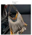 Detail view of grey fringe crossbody bag featuring vibrant yellow interior contrast - Gray