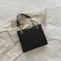 Retro black crocodile embossed tote bag with gold chain strap on stylish background - Black