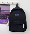 Dettaglio zaino in velluto a coste nero con patch viola e ciondolo in peluche bianco - Nero
