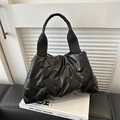 Minimalist black quilted tote bag with padded texture and wide woven top handles - Black