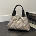Modern champagne gold quilted tote bag with padded texture and black canvas handles - Gold