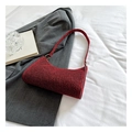Détail montrant la texture pailletée rouge et la forme demi-lune épurée du sac à main - Rouge