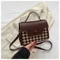 Detail van vintage bruine crossbodytas met houndstooth-patroon op een crèmekleurig pak - Koffie Ruit