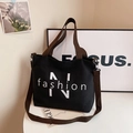 Casual black canvas tote bag with brown shoulder strap, spacious daily commuter handbag. - Black