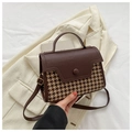 Detail van de retro bruine crossbodytas met pied-de-poule stof en een ronde knoopsluiting - Koffie Hahnentritt