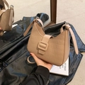 Sac demi-lune beige avec texture crocodile et boucle carrée vu dans un reflet de miroir - Kaki