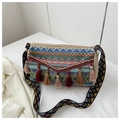 Dettaglio della borsa boho tessuta con motivi geometrici e nappe di cotone colorate - Blu navy