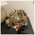 Detail of plaid drawstring bucket bag with woven handle and plush eye doll charm - Green with Pendant