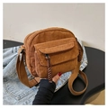 Detalle del bolso bandolera de pana marrón con textura de canalé y tirador de cremallera - Tostado