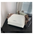 Close-up of white lychee leather handbag with striped canvas strap on black wood - White