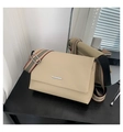 Close-up of minimalist beige crossbody bag with textured leather and striped woven strap - Khaki