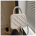 Macro shot of white quilted leather square bag with golden hardware and round handle - White