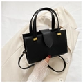 Detalle del bolso negro de piel con textura lichi y elegante hebilla de metal dorado - Negro
