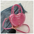 Close-up of pink heart-shaped bag featuring baby text and red cross print detail - Barbie Pink